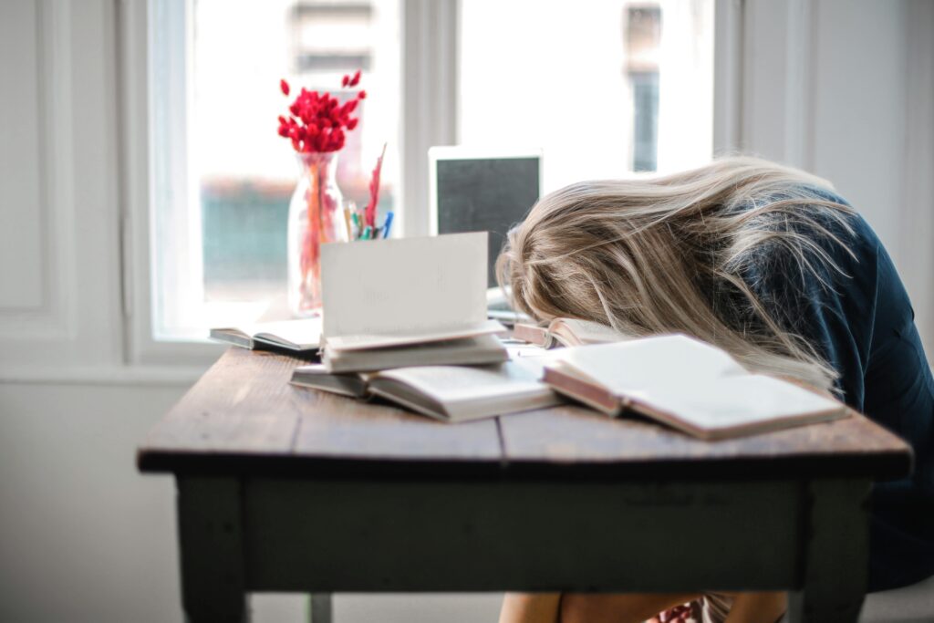 Estudante cansado tentando saber como estudar mesmo sem vontade diante dos livros

